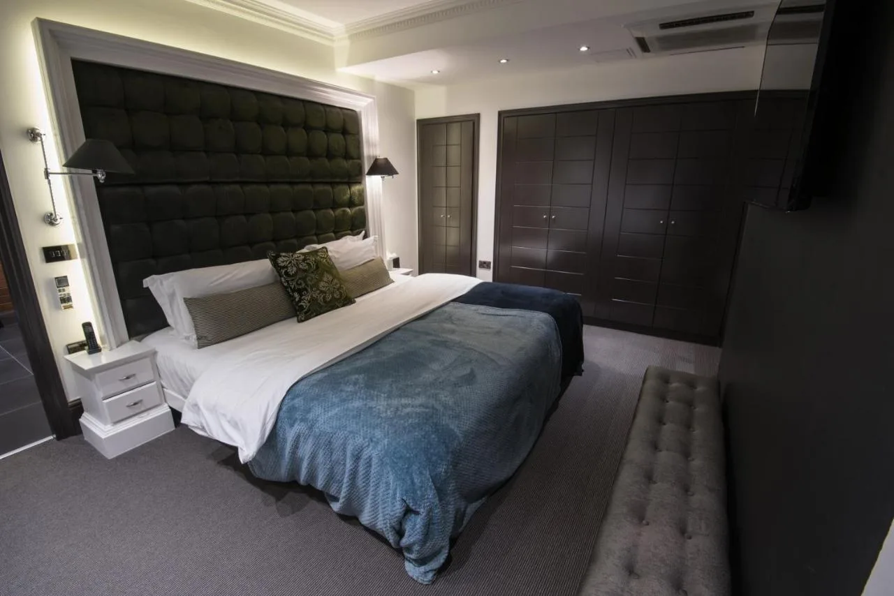 a bedroom with a large bed with a large headboard at The Exhibitionist Hotel in London