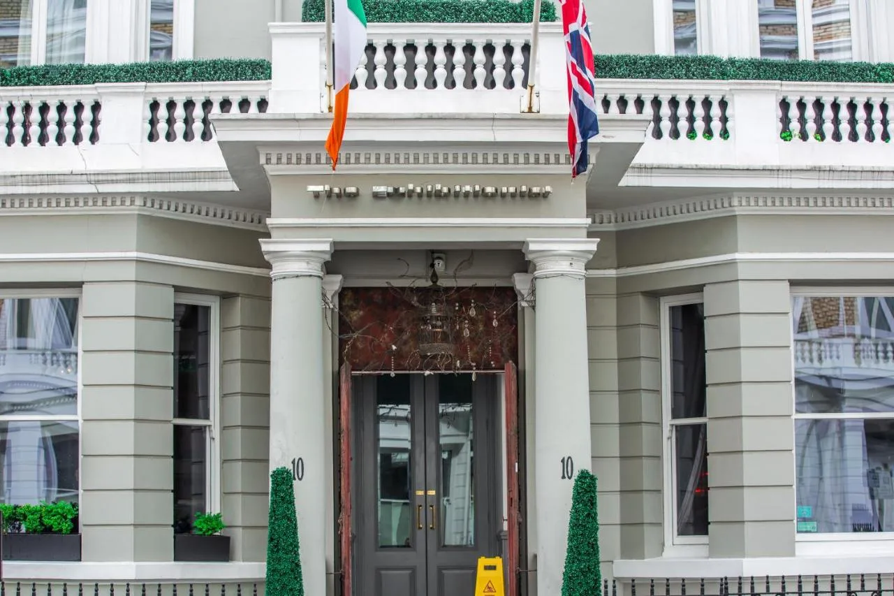 a white building with flags in front of it at The Exhibitionist Hotel in London