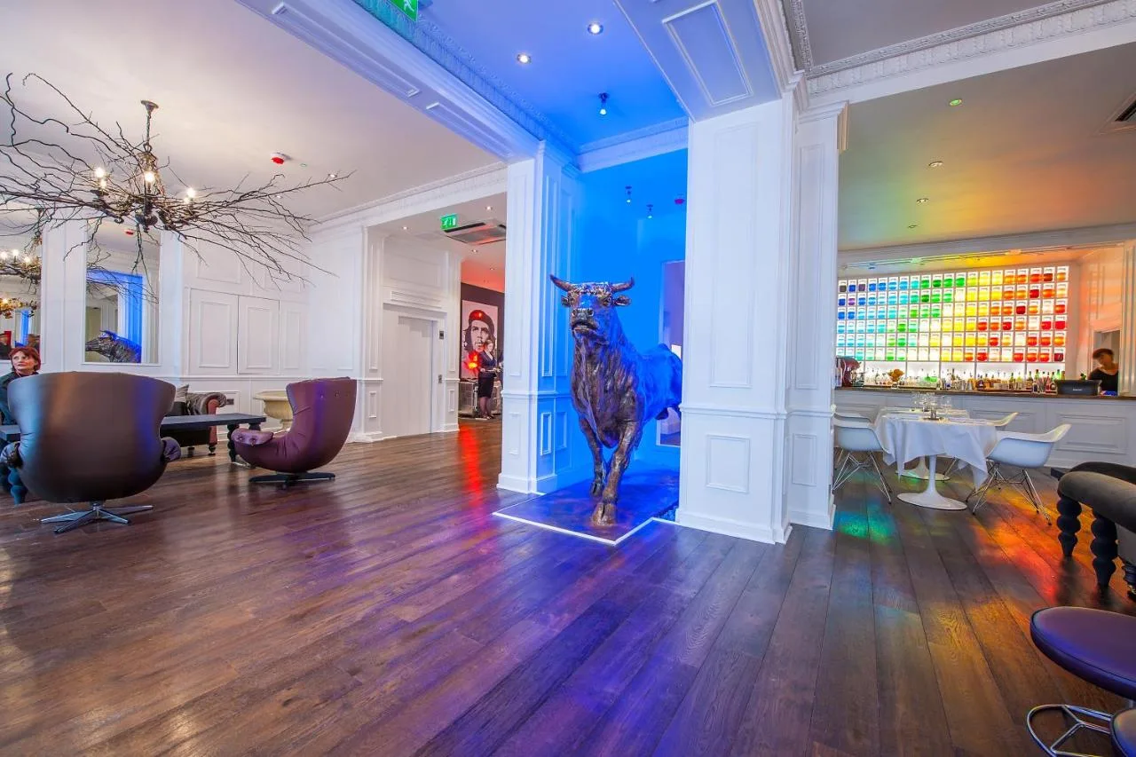 a restaurant with a statue of a giraffe in the middle of a room at The Exhibitionist Hotel in London