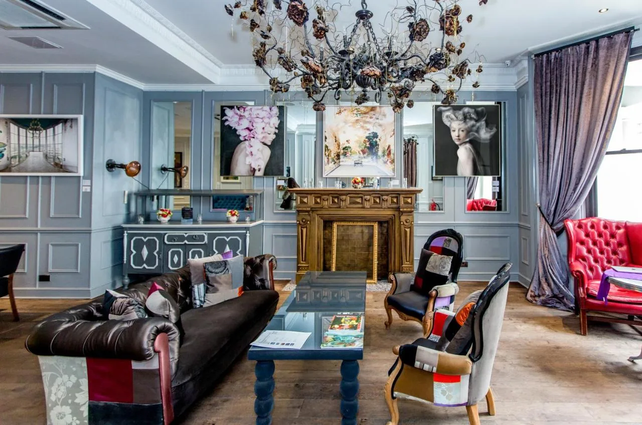 a living room with a couch and a chandelier at The Exhibitionist Hotel in London